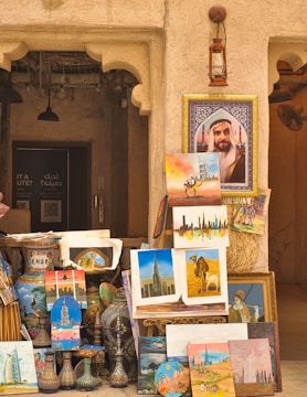 A man standing next to a pile of paintings