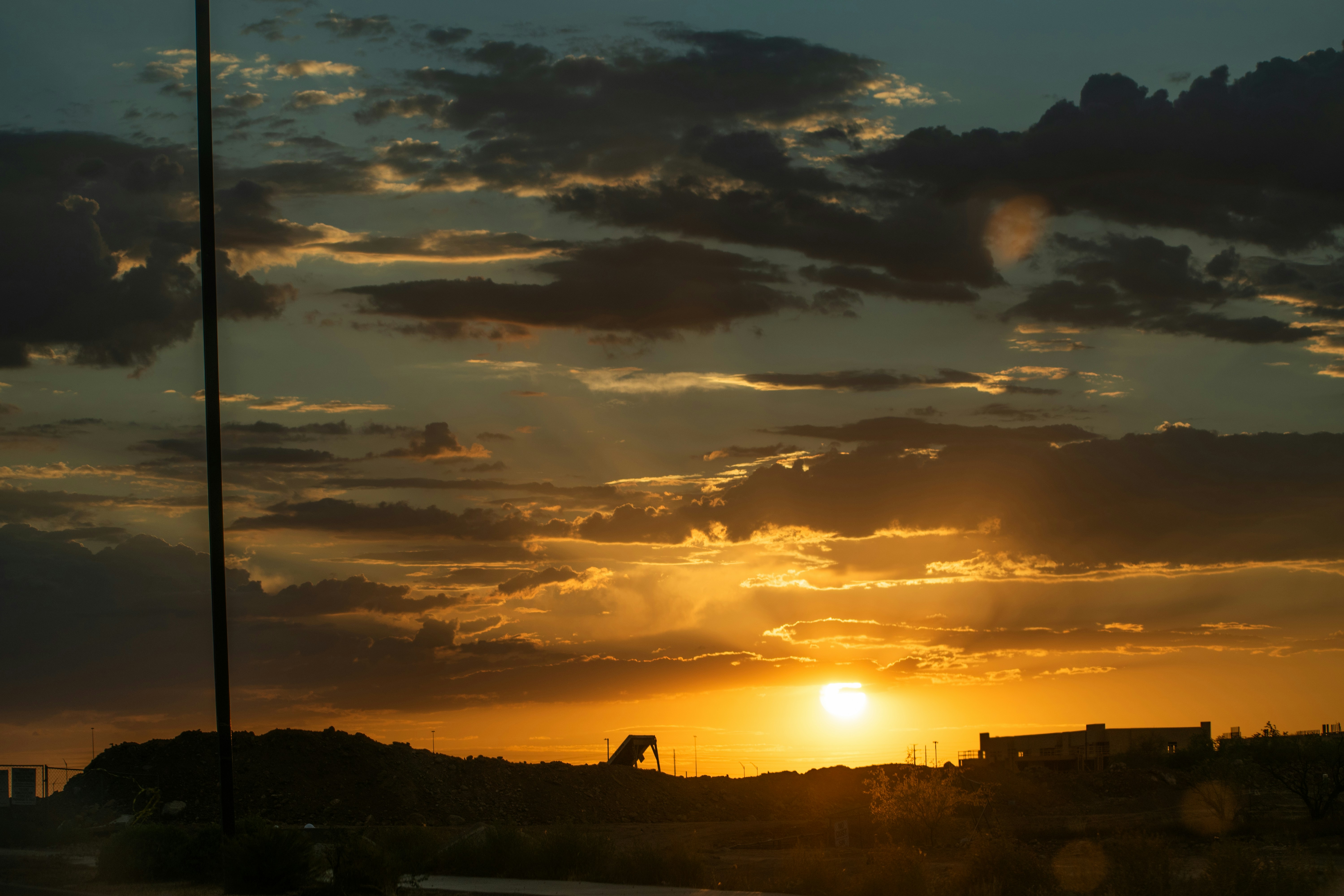 The sun is setting in the sky over a field
