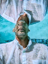 A man in a white shirt is floating in the water