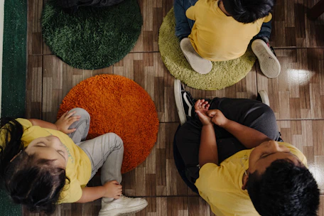 A group of people sitting on top of a wooden floor