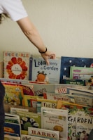 A person reaching for a book on a shelf