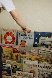 A person reaching for a book on a shelf