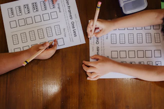 A couple of people sitting at a table with paper