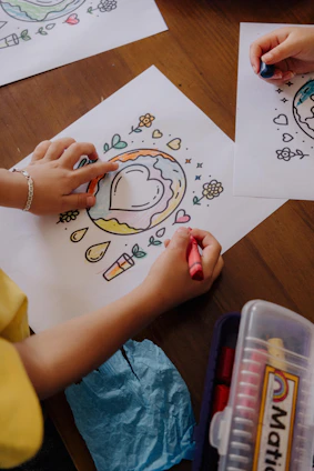 A child is drawing on paper with crayons