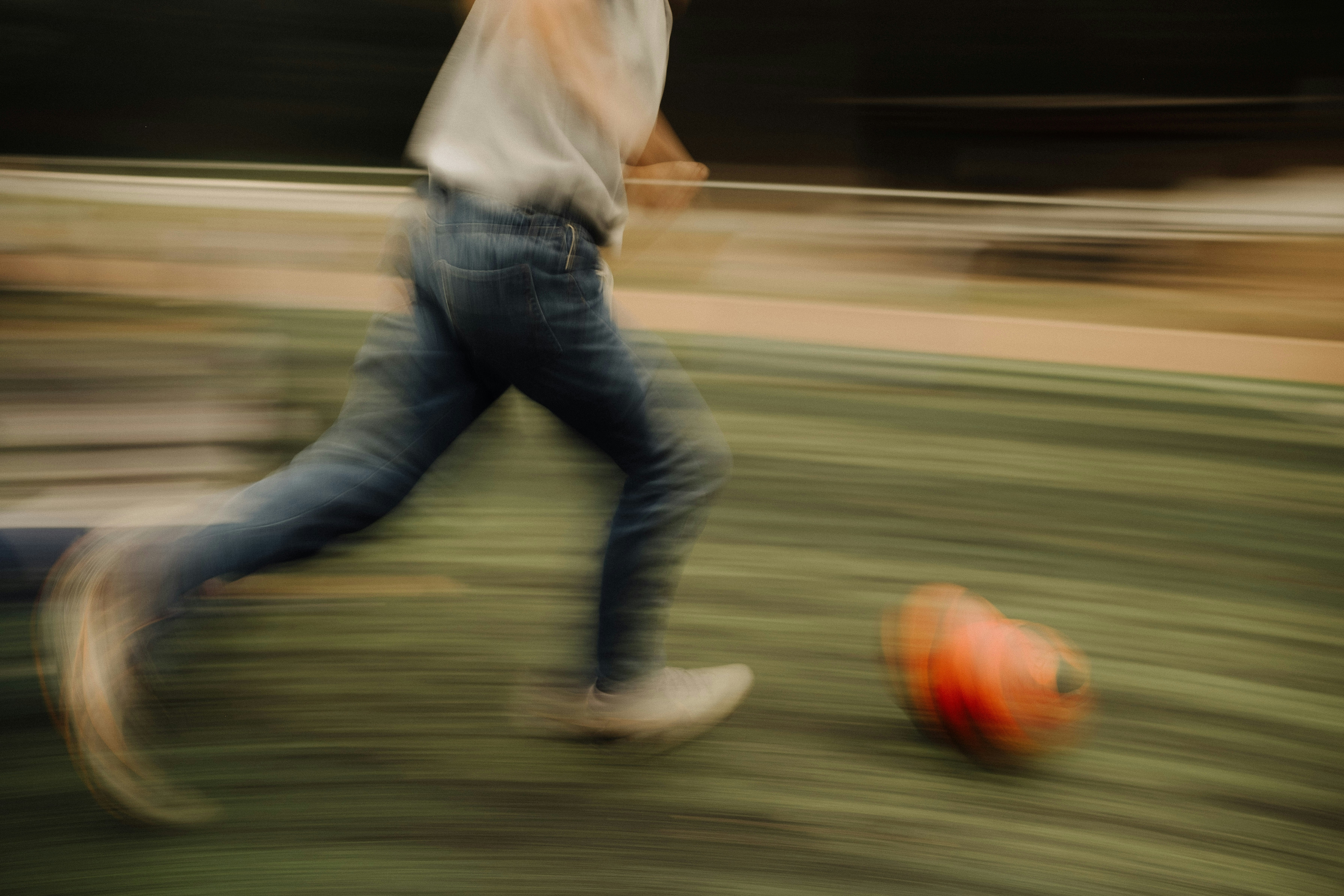 A blurry photo of a man kicking a soccer ball