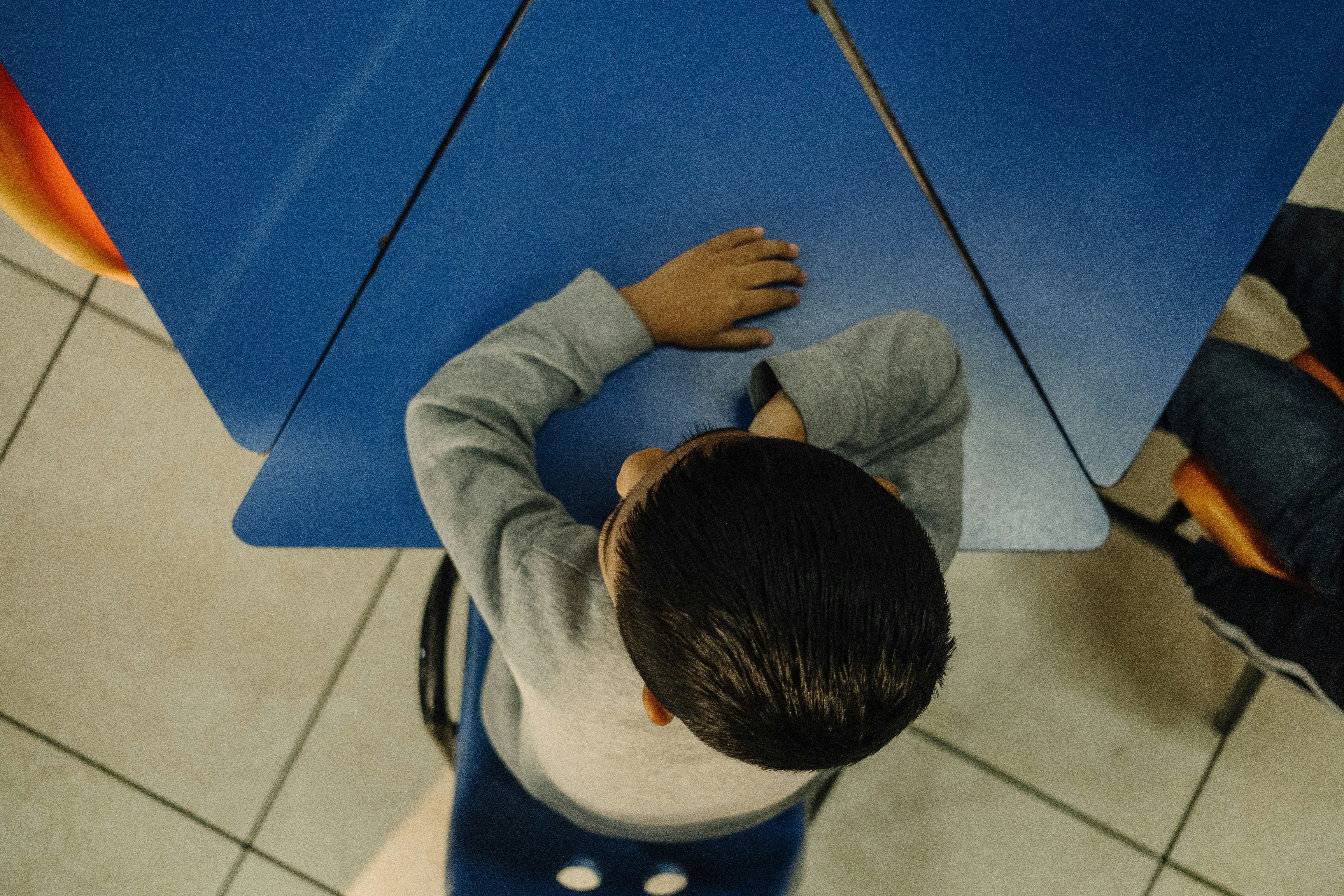 A young boy sitting on a stool holding an umbrella
