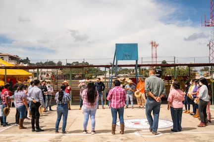 A group of people standing around a basketball court