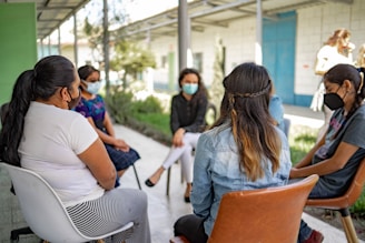 A group of people sitting around each other