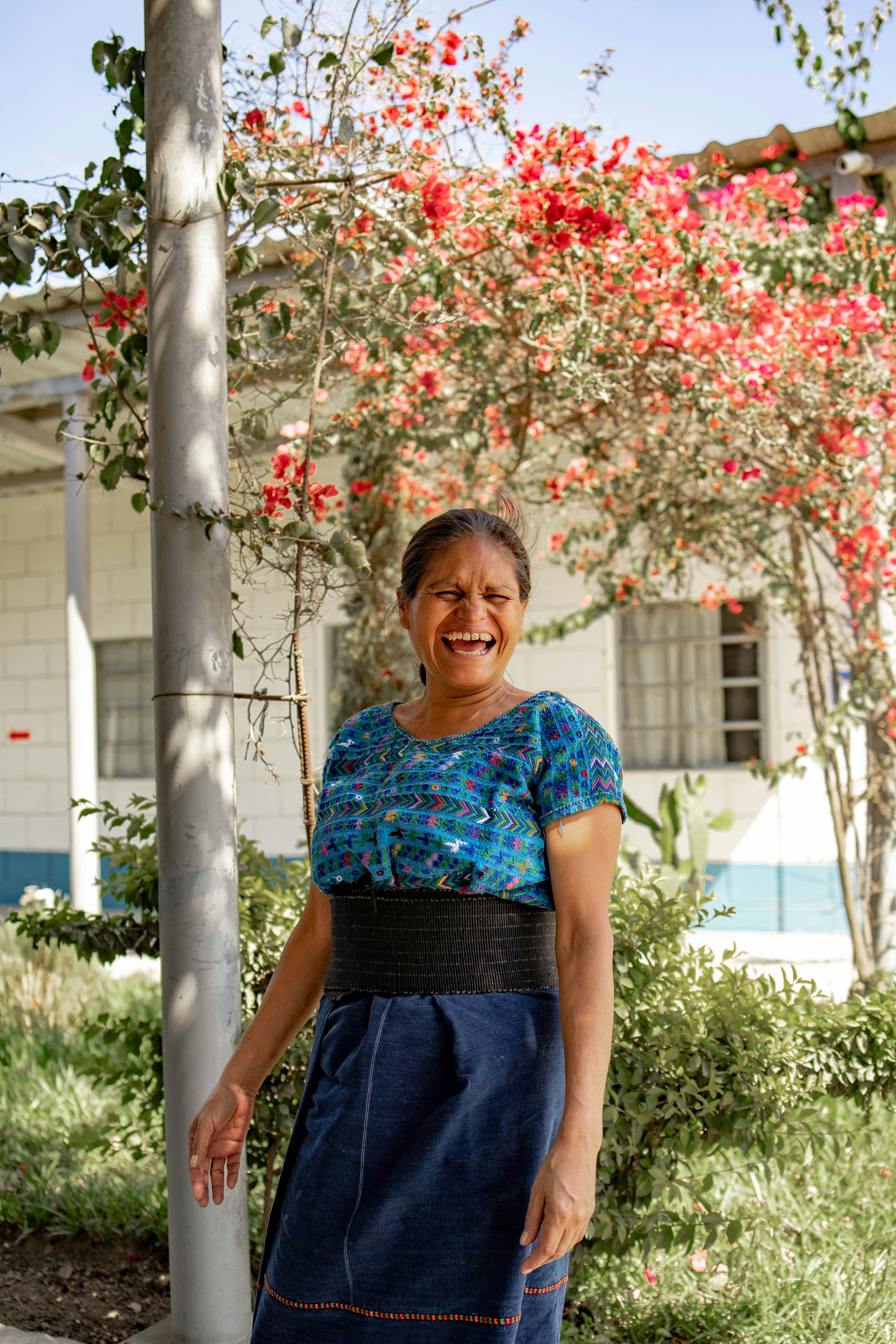 A woman in a blue dress standing next to a pole