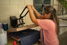 A woman working on a machine in a room