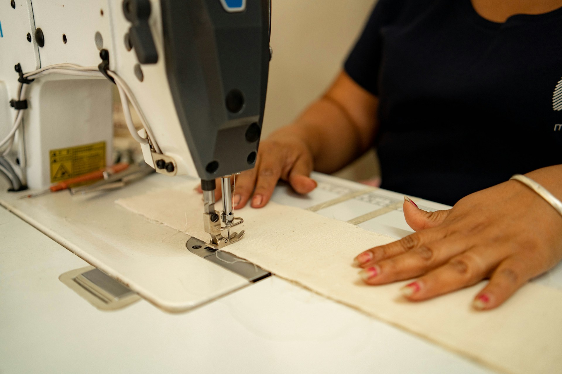 A woman using a sewing machine on a table