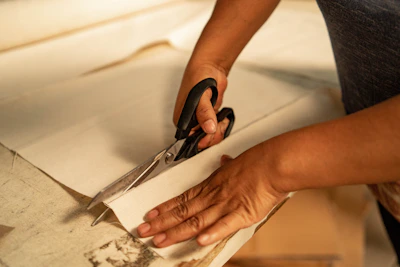 A person cutting a piece of paper with a pair of scissors