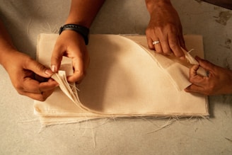 Two people are working on a piece of cloth