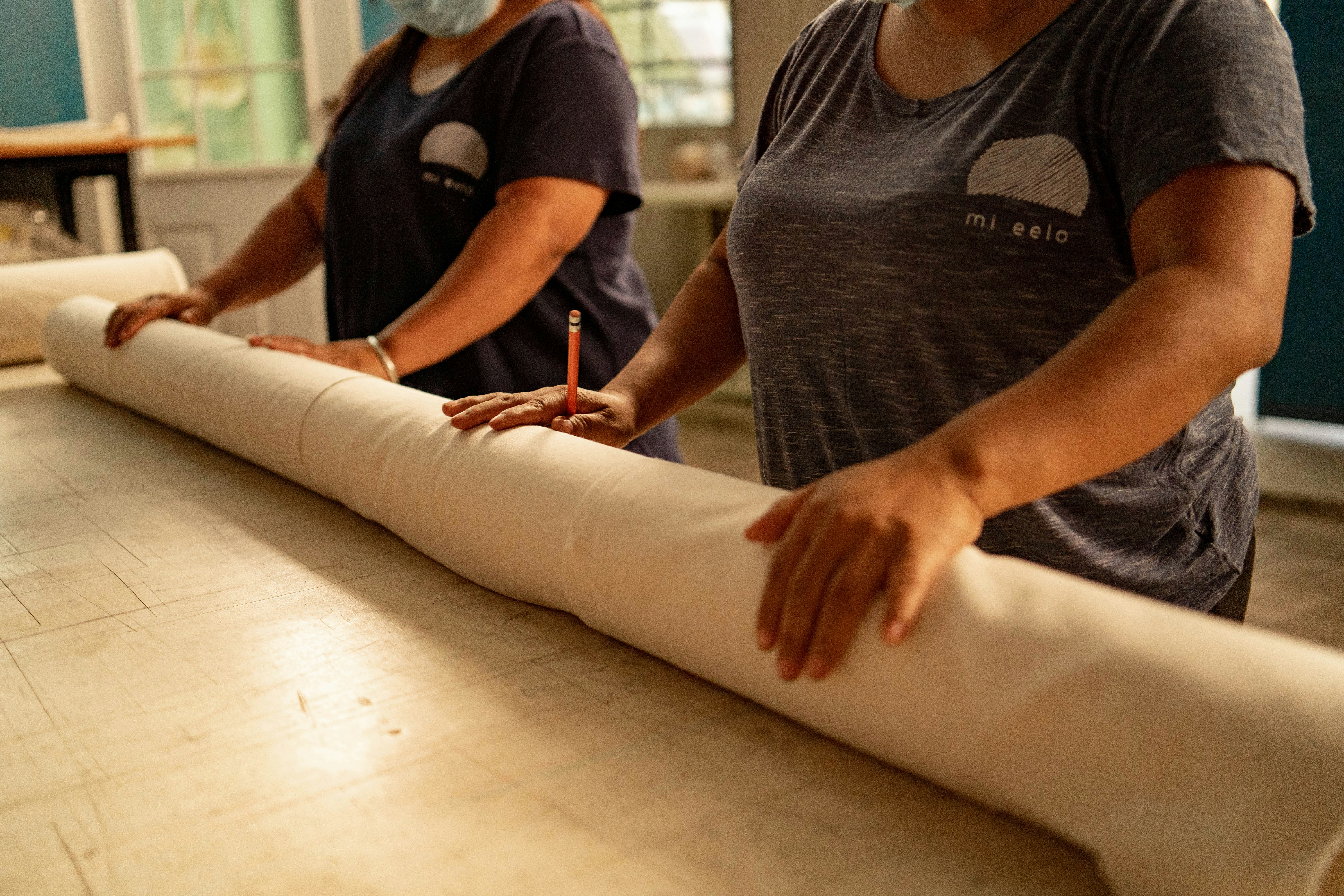 Eine Frau, die eine Papierrolle auf einem Tisch ausrollt