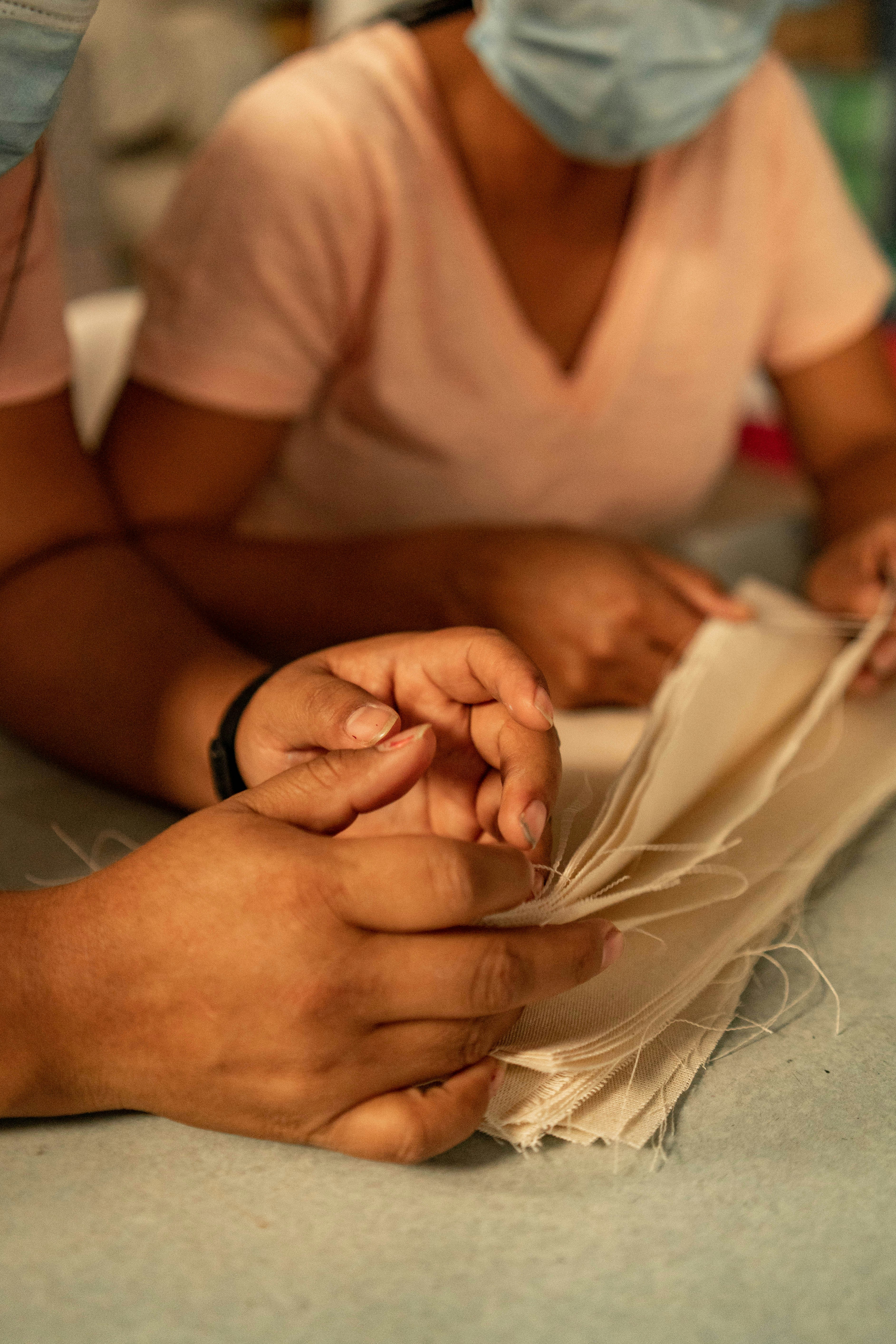 Two people in masks are working on a piece of paper