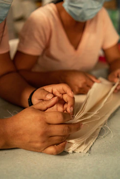 Two people in masks are working on a piece of paper