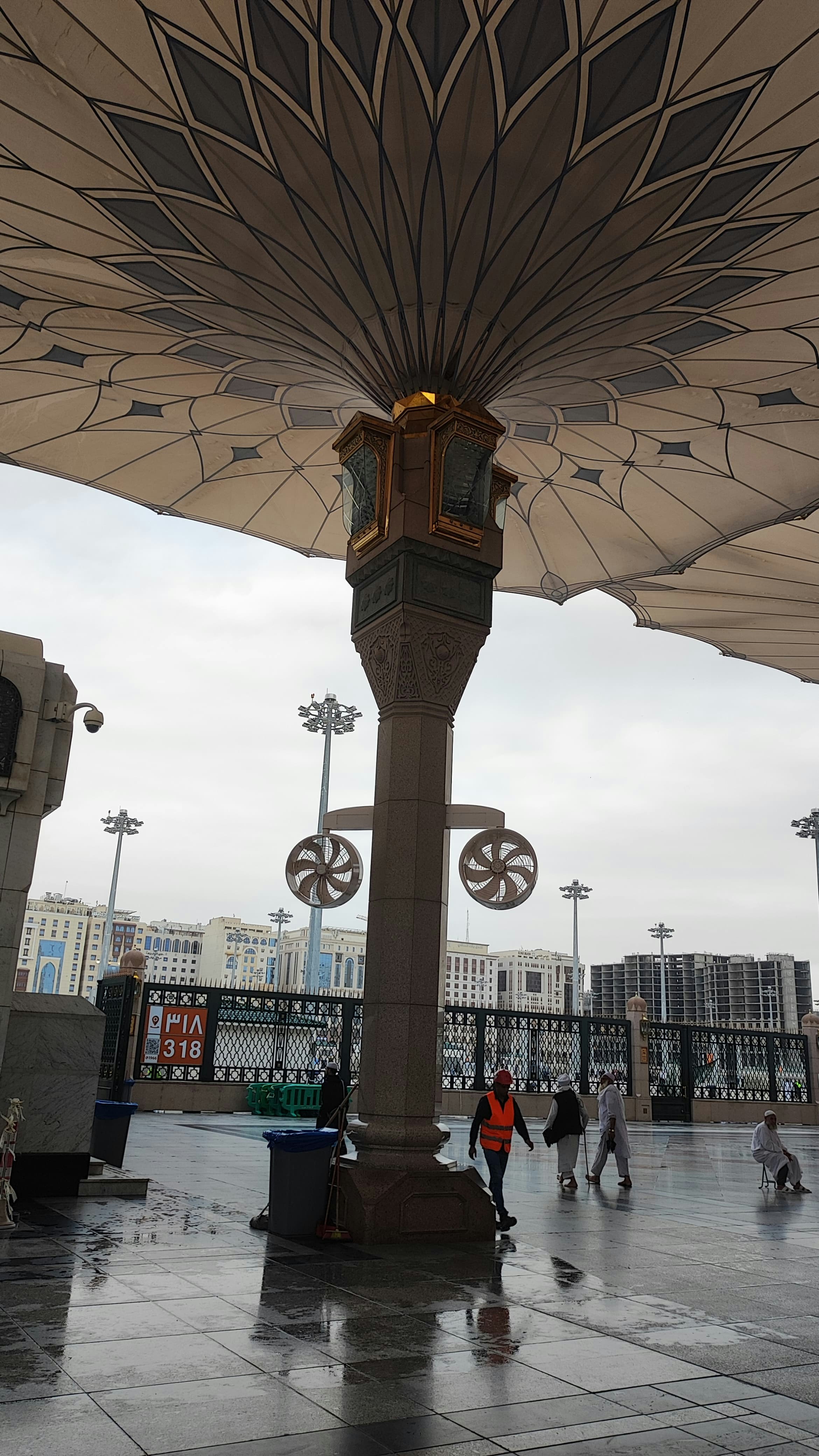 A group of people walking under a large umbrella