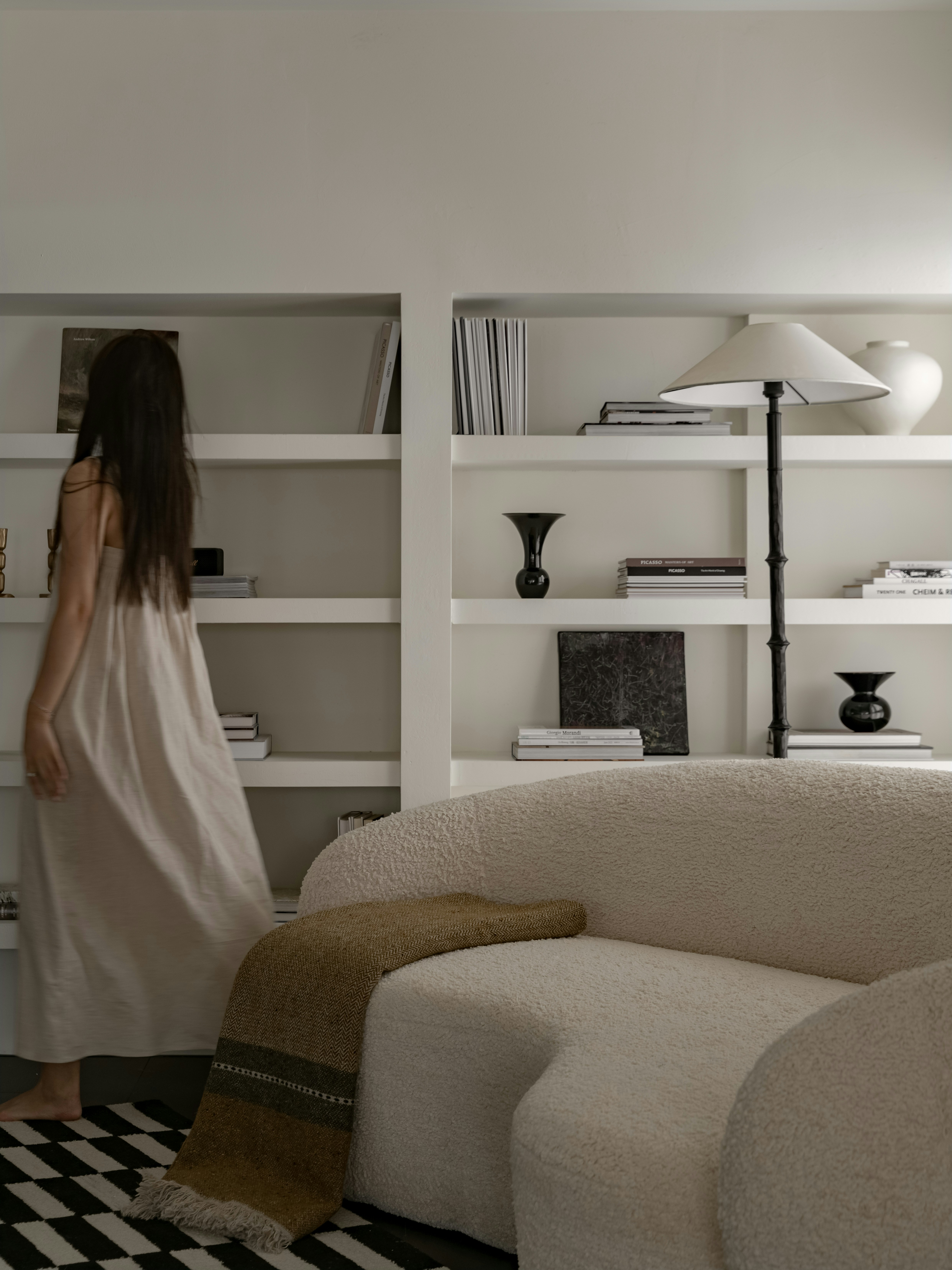 A woman in a white dress standing in a living room
