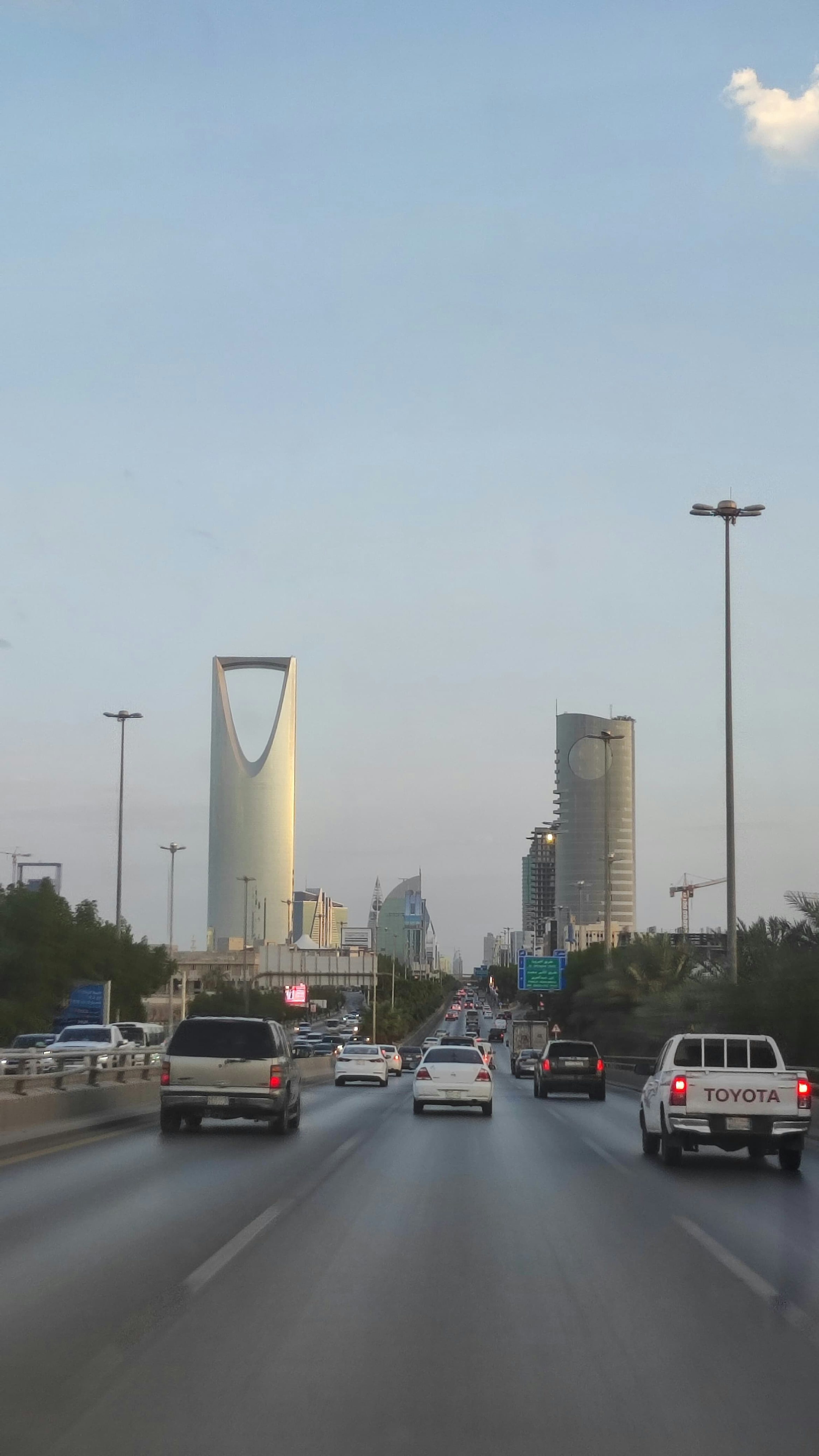 A view of a highway with cars and buildings in the background