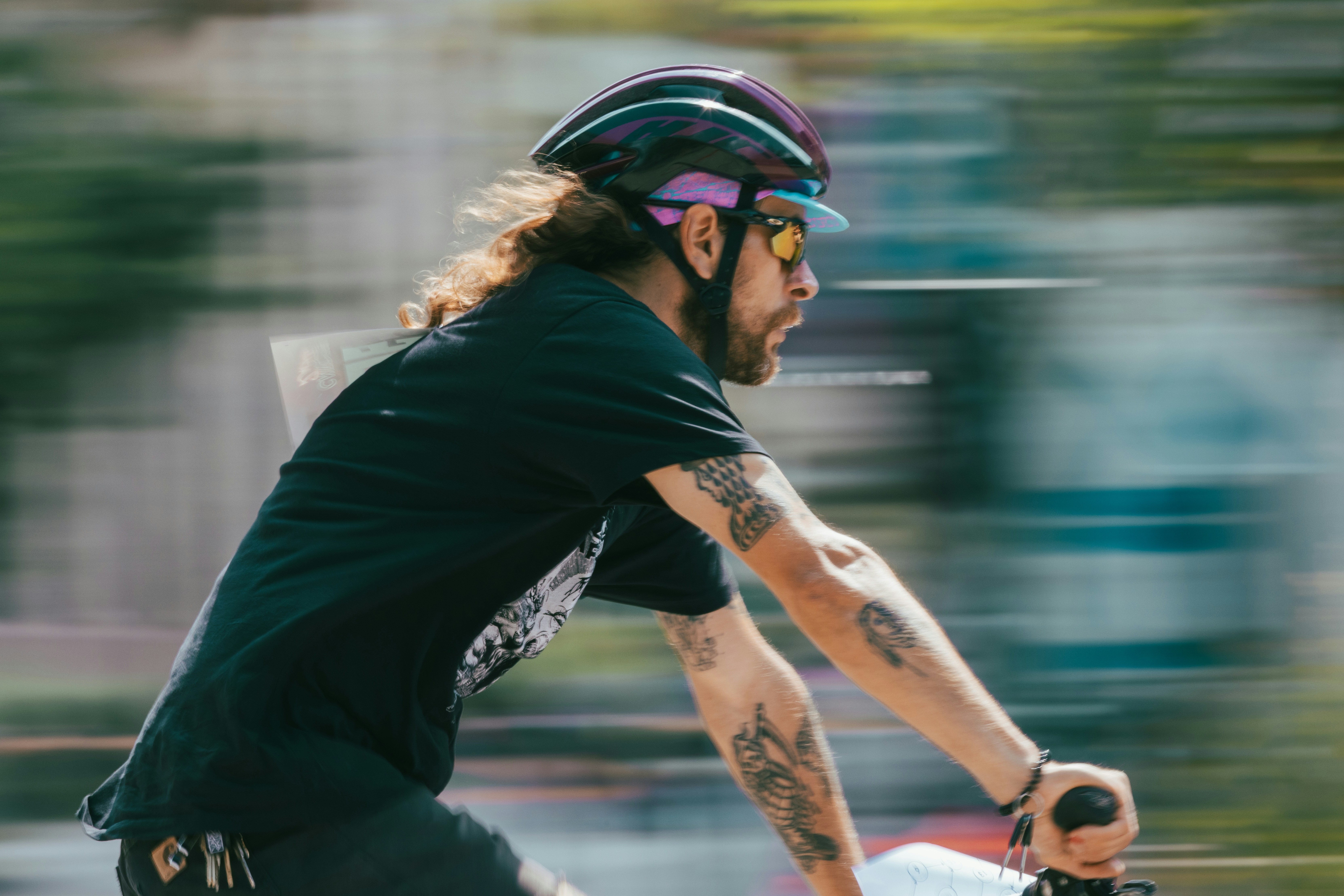 Man with long hair riding a bike, motion blur