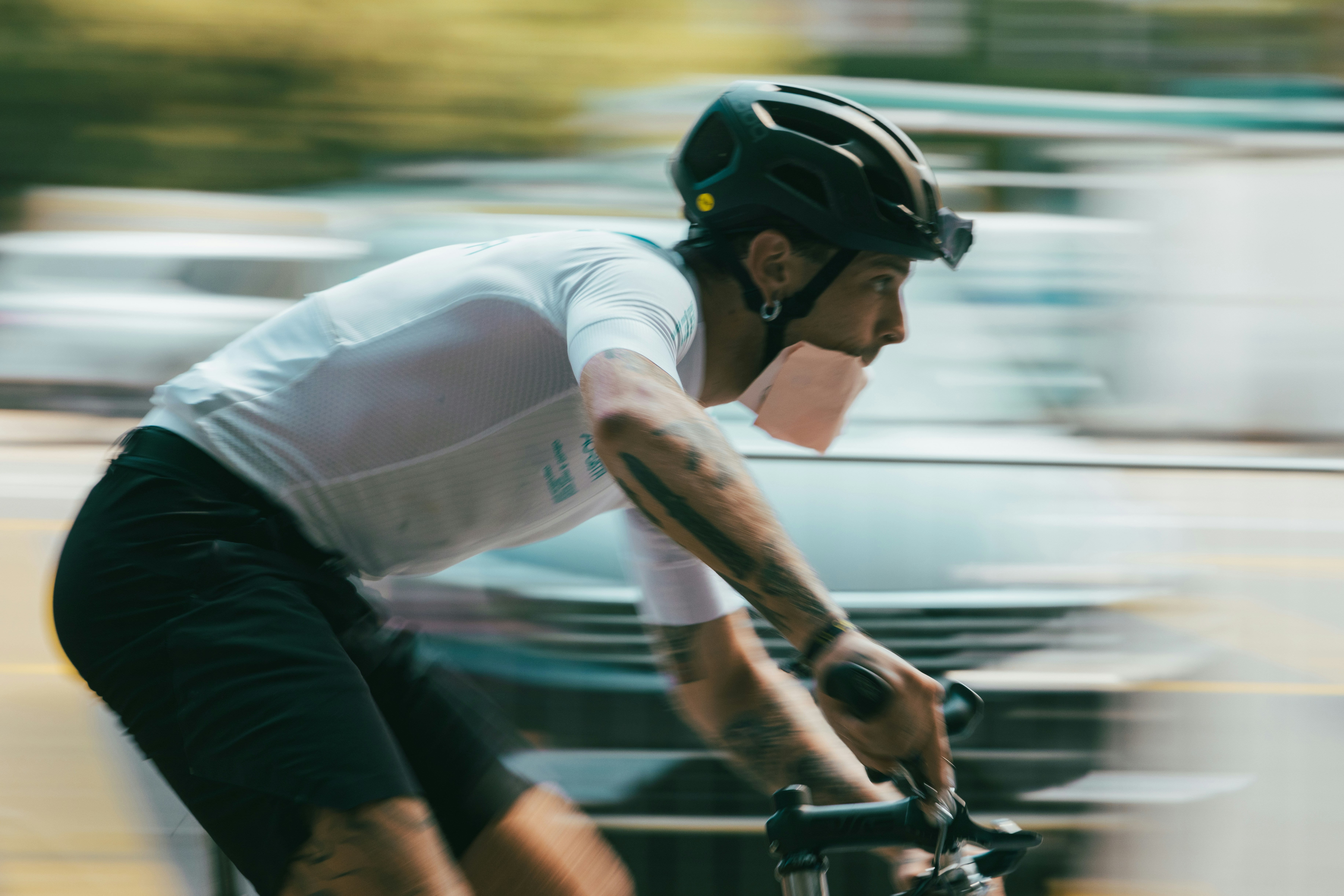 A man riding a bike down a street next to a car