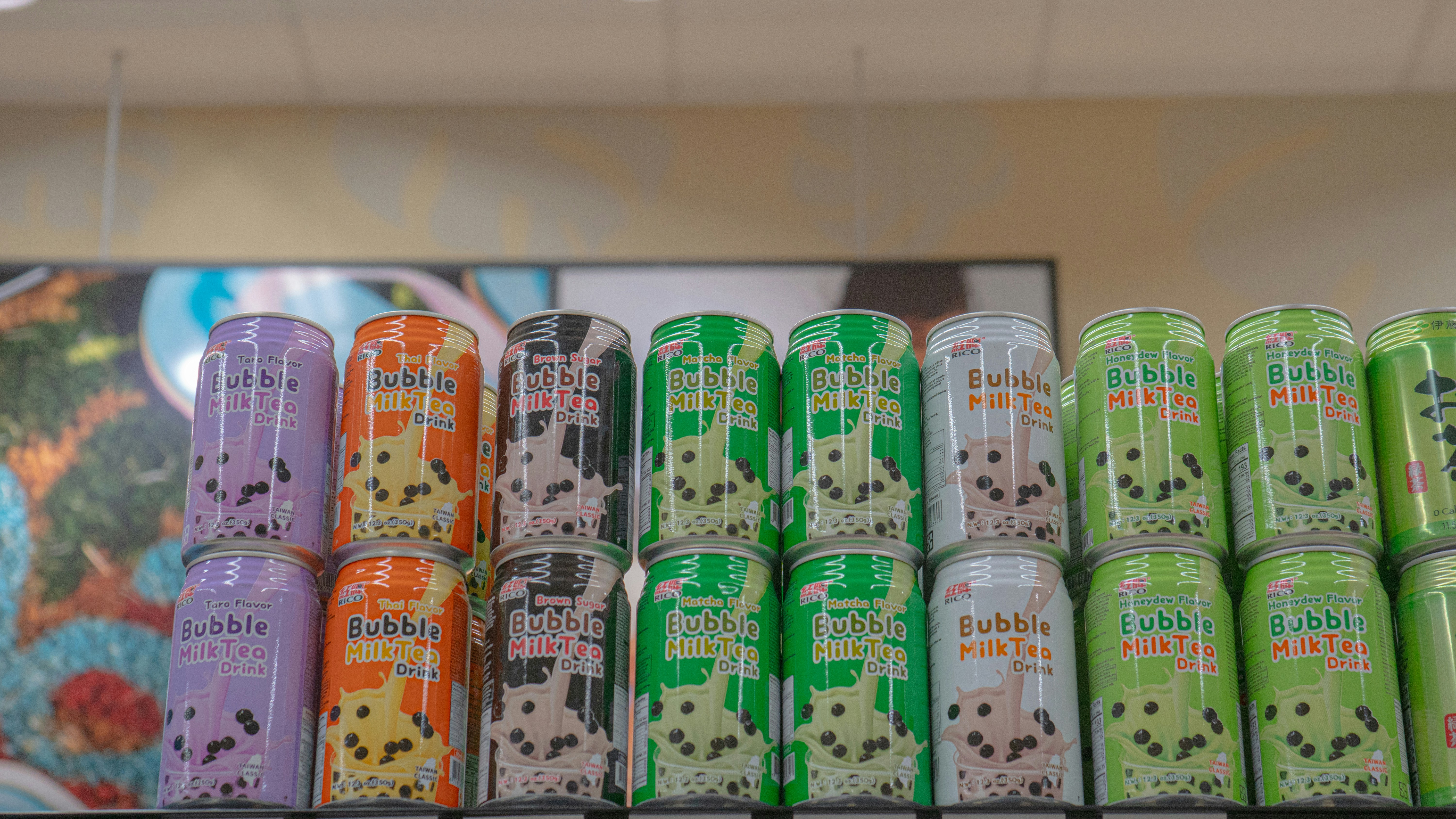 A row of different colored lighters sitting on top of a shelf