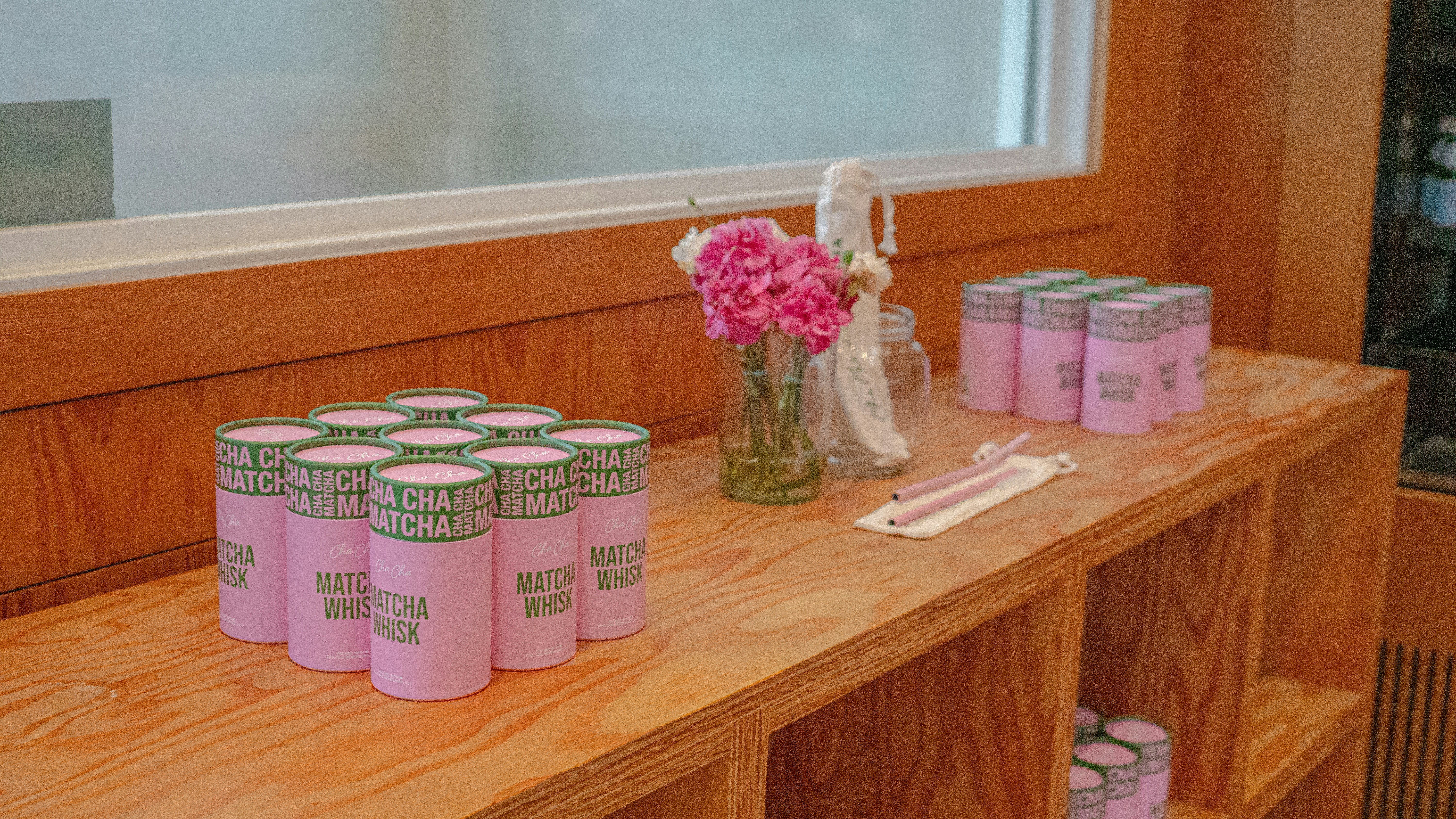 A wooden table topped with lots of pink candles