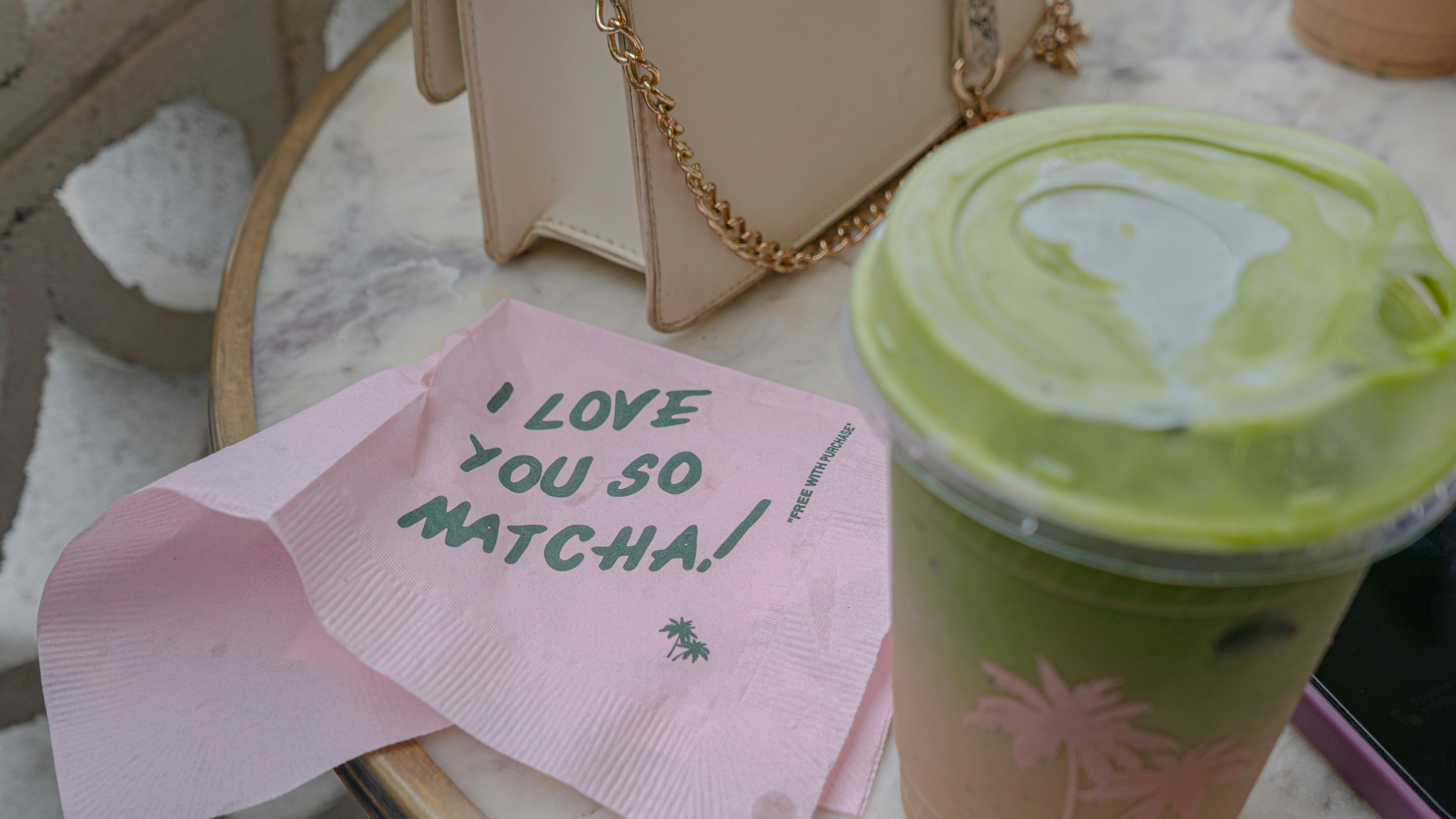 A cup of green tea next to a note that says i love you so mitchell