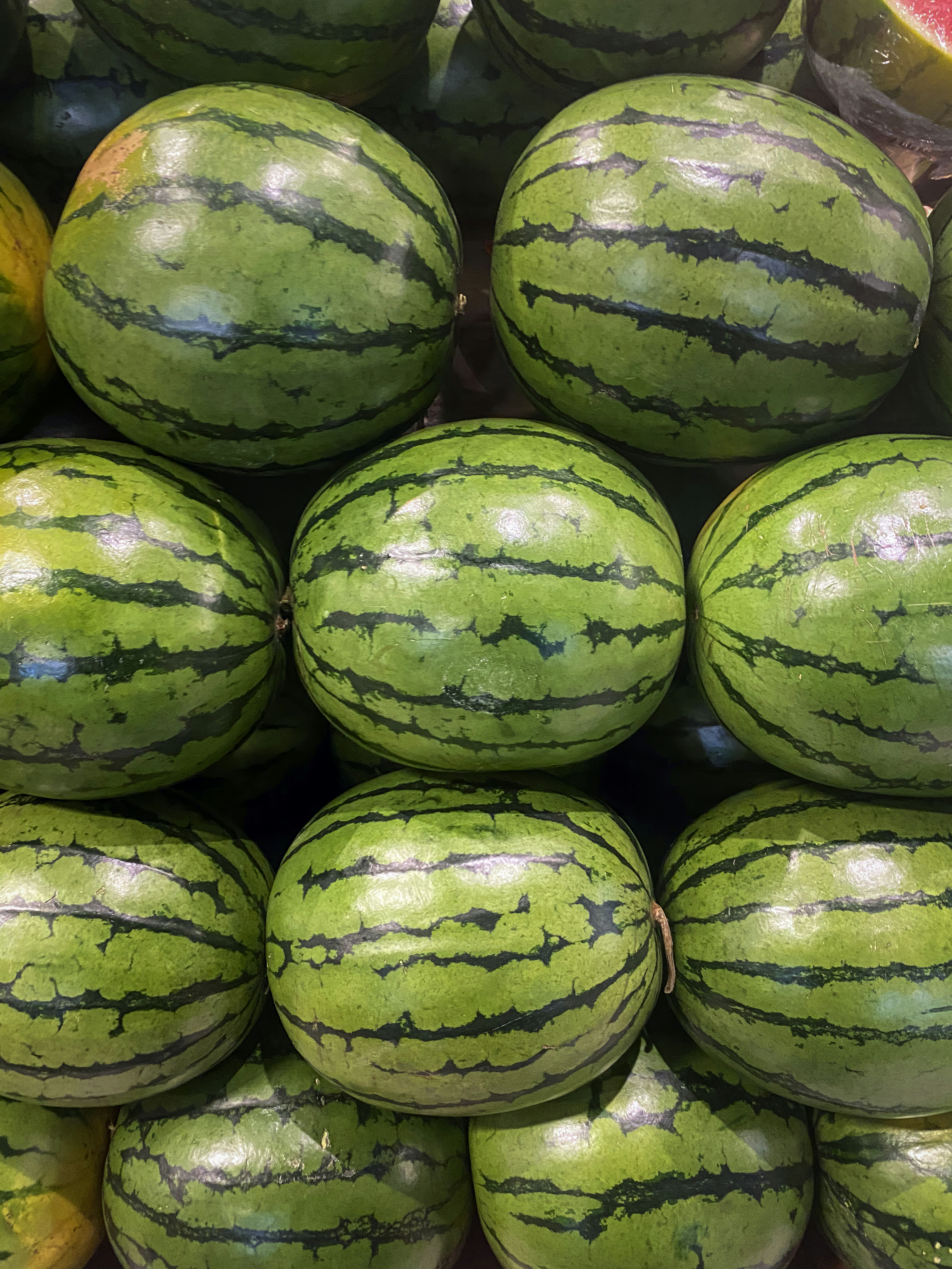 A pile of watermelon sitting on top of each other