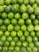 A large pile of limes sitting on top of each other