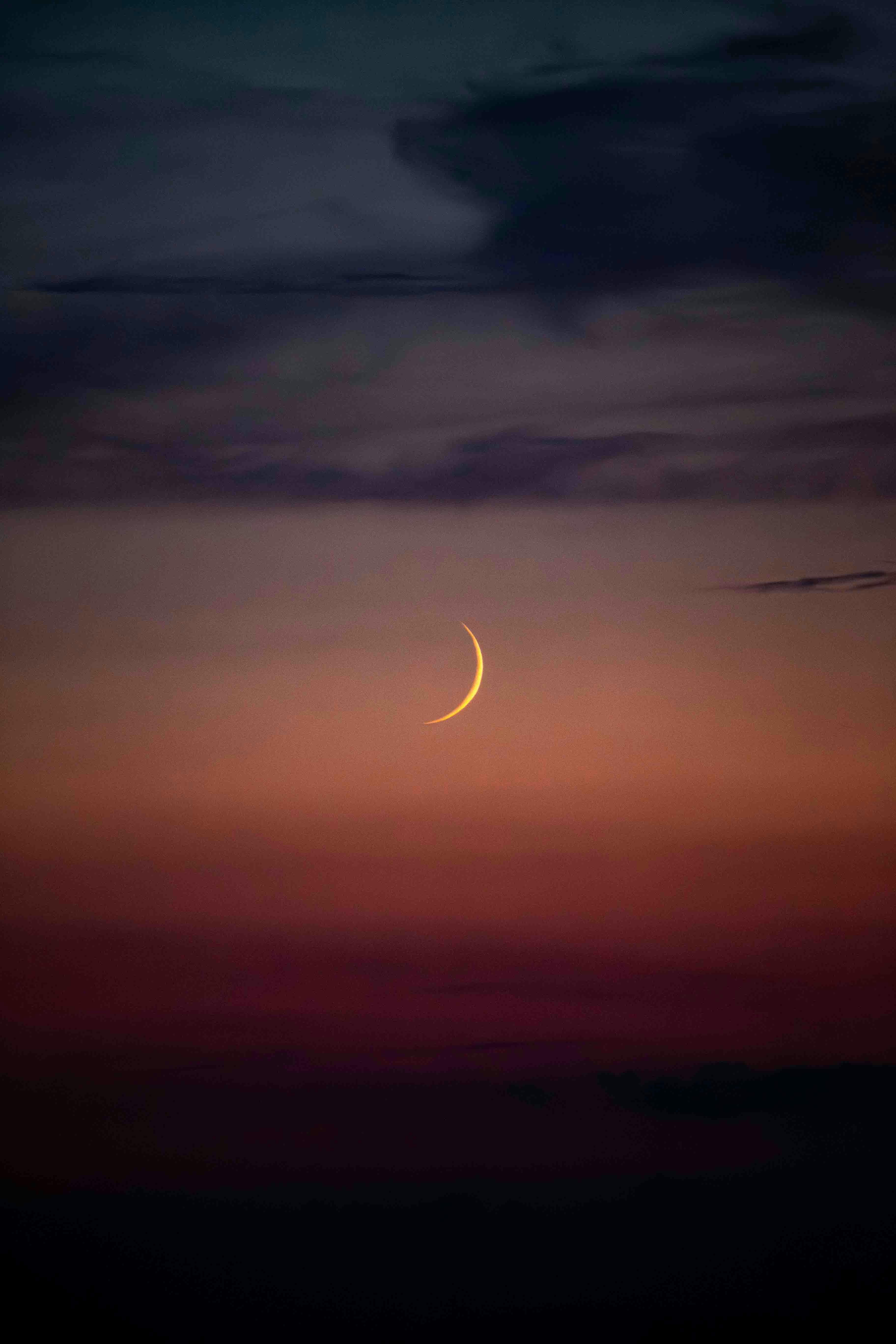 A crescent is seen in the sky at night