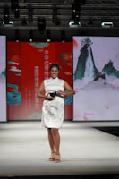 A woman in a white dress on a runway