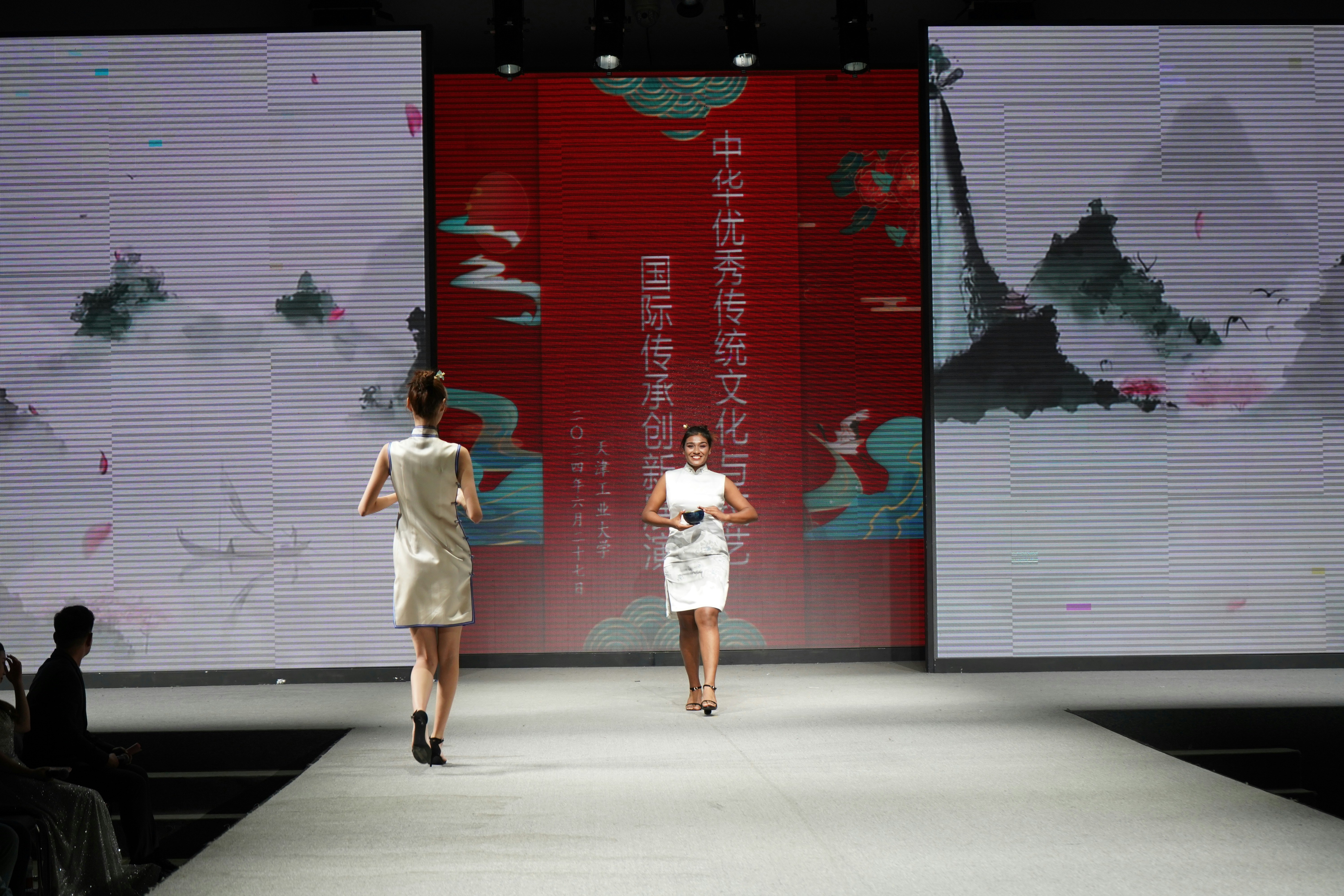 A couple of women walking down a runway