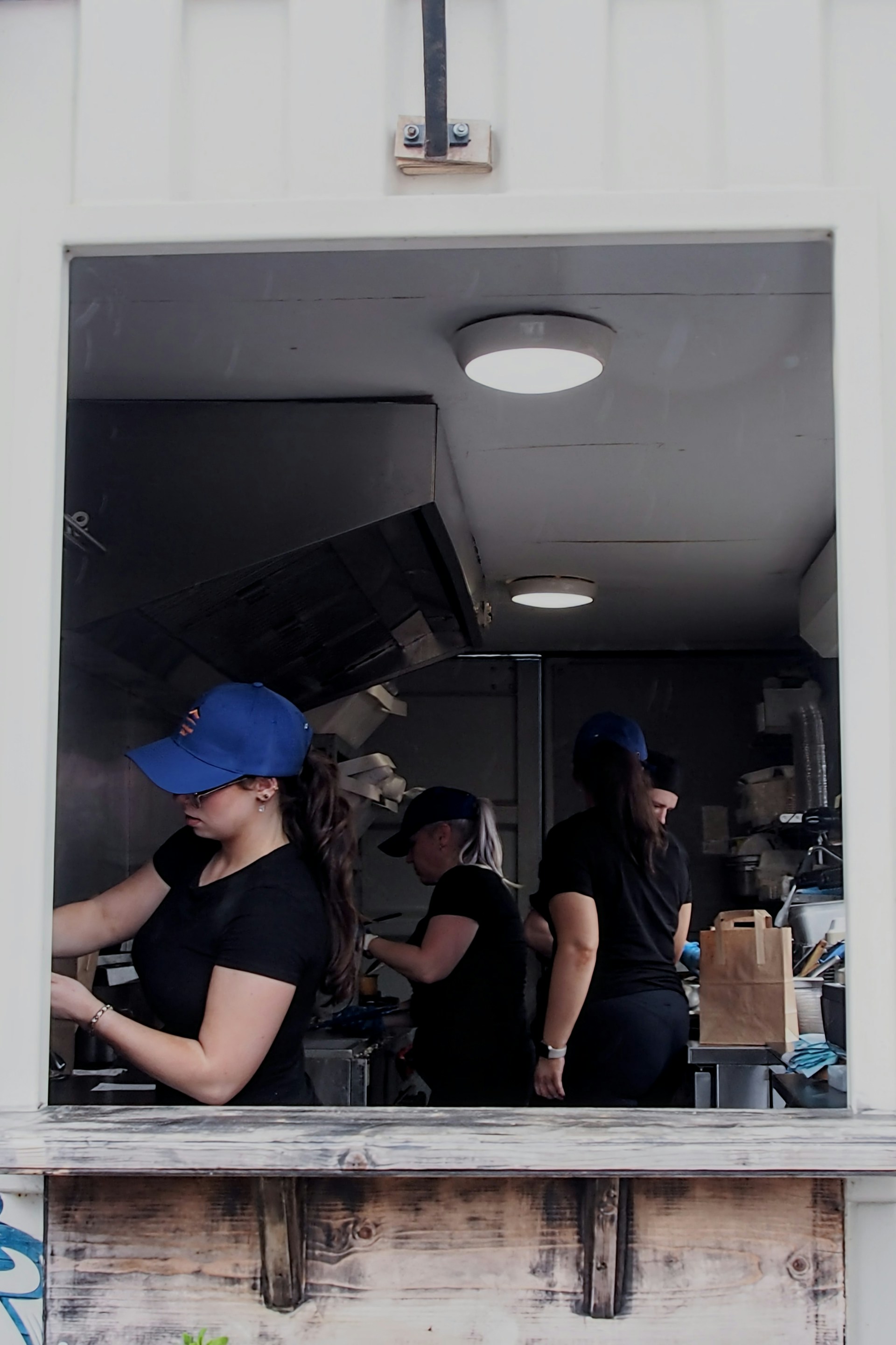 A group of people standing inside of a kitchen