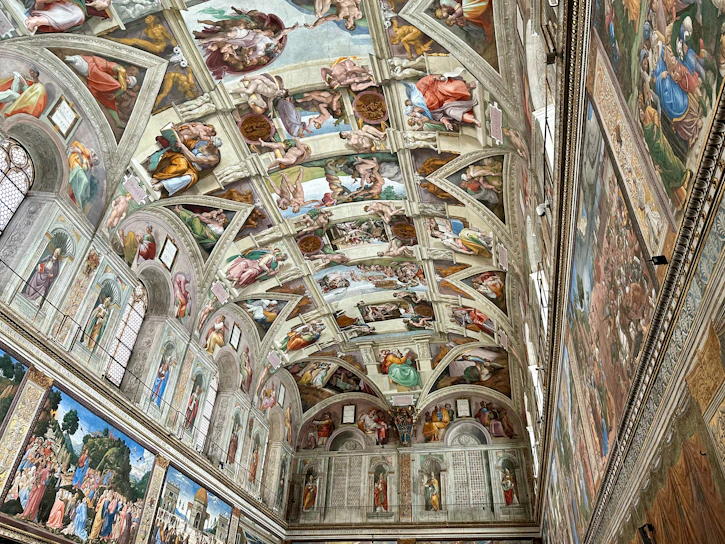 The ceiling of a building with many paintings on it