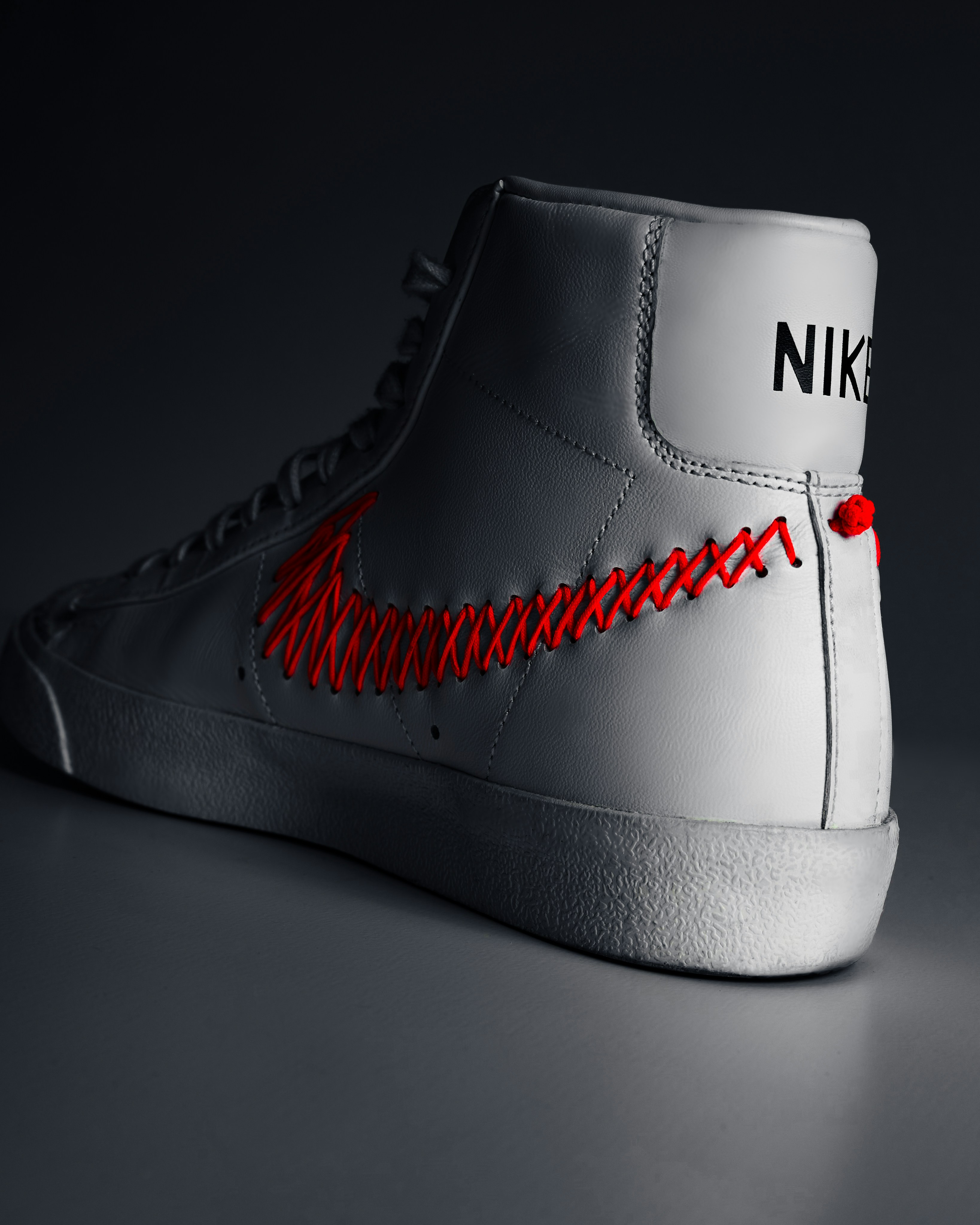 A pair of white sneakers with red laces