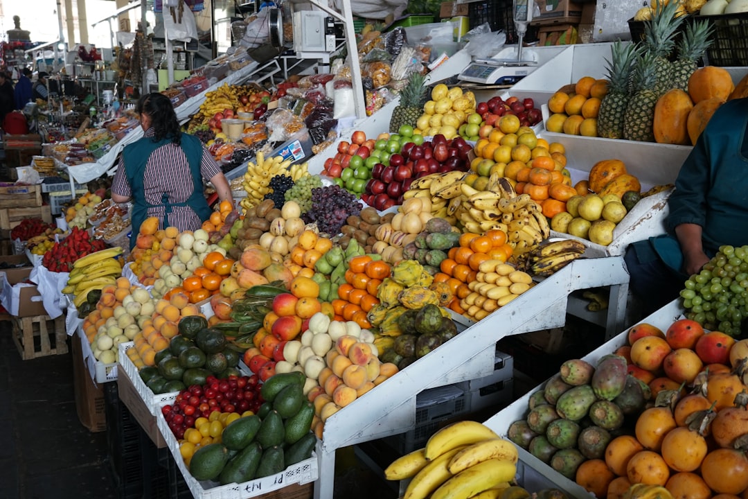 A woman standing in front of a fruit stand,