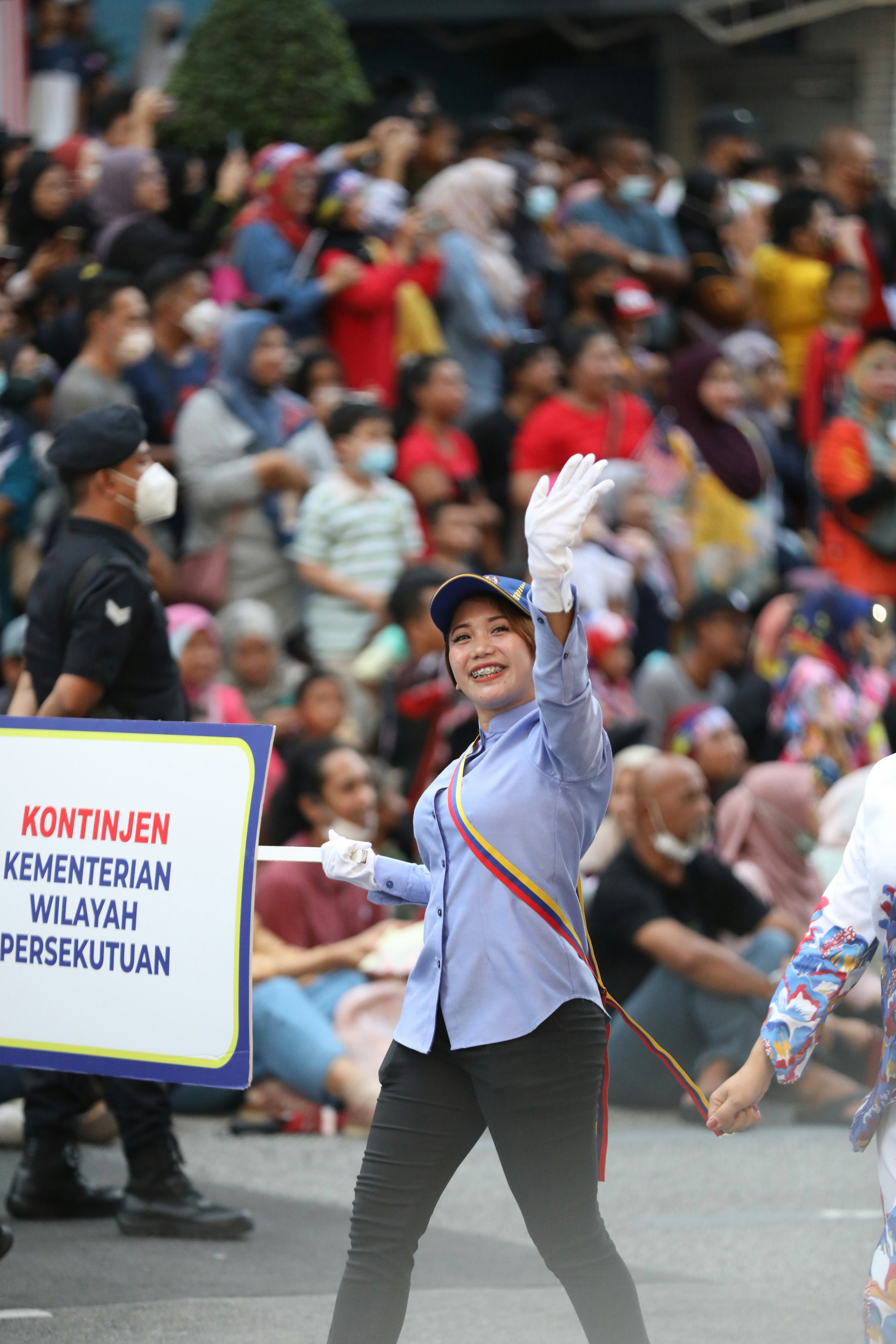 Seorang wanita memegang tanda di depan kerumunan