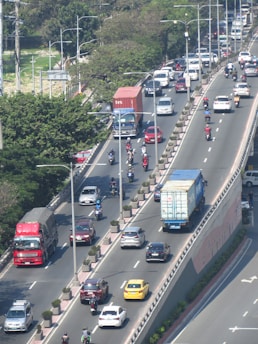 A highway filled with lots of traffic next to trees