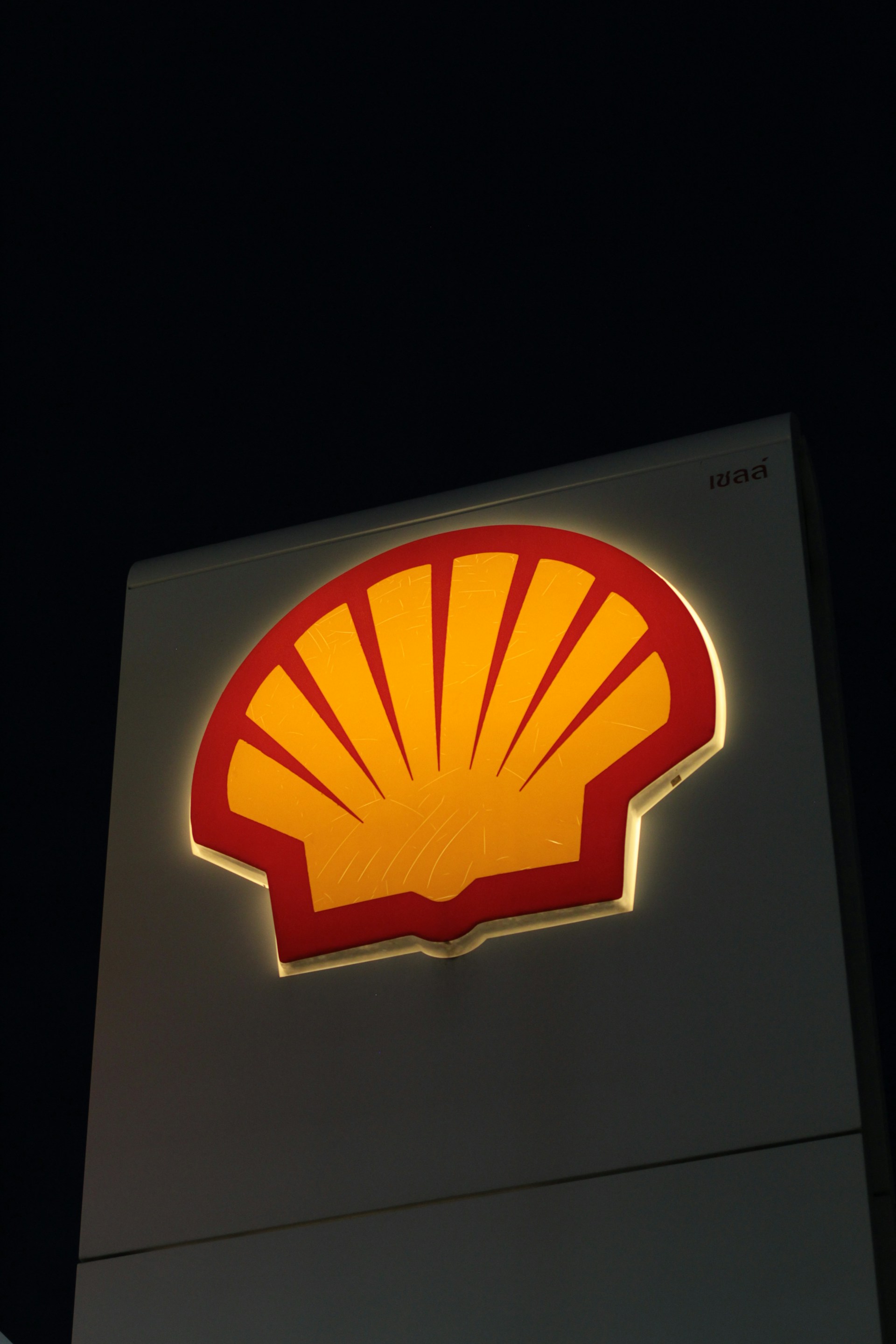 A shell gas station sign lit up at night