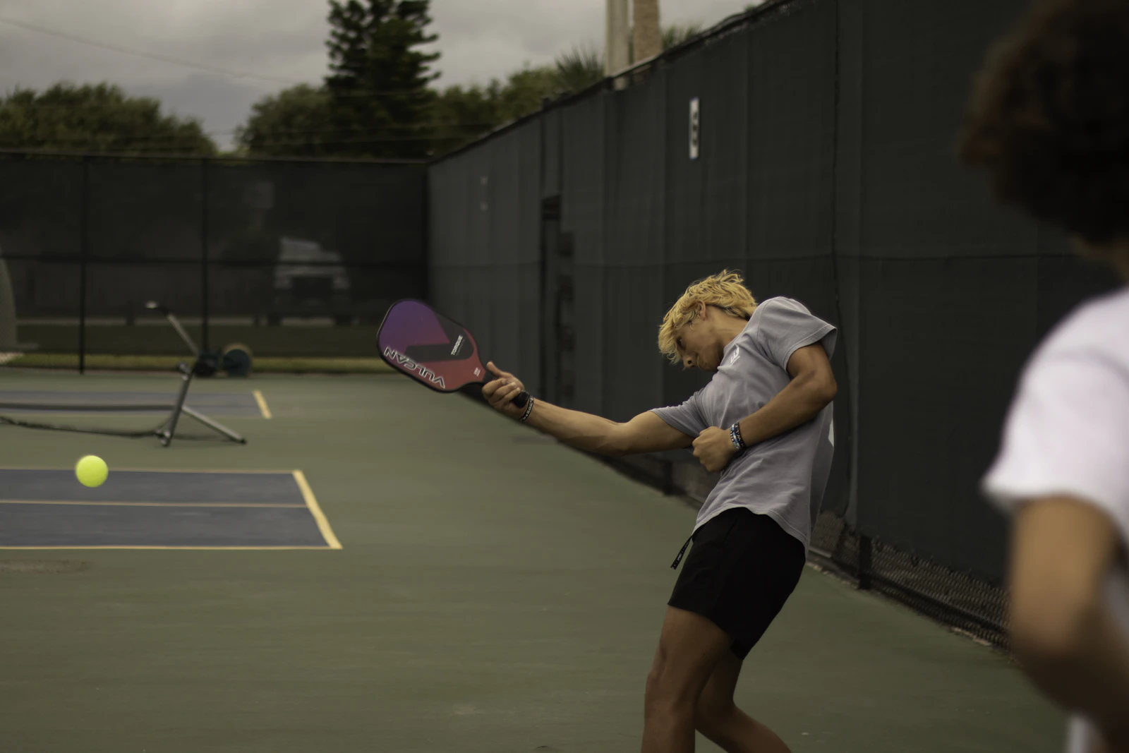 A player mid-swing returning a ball on the court