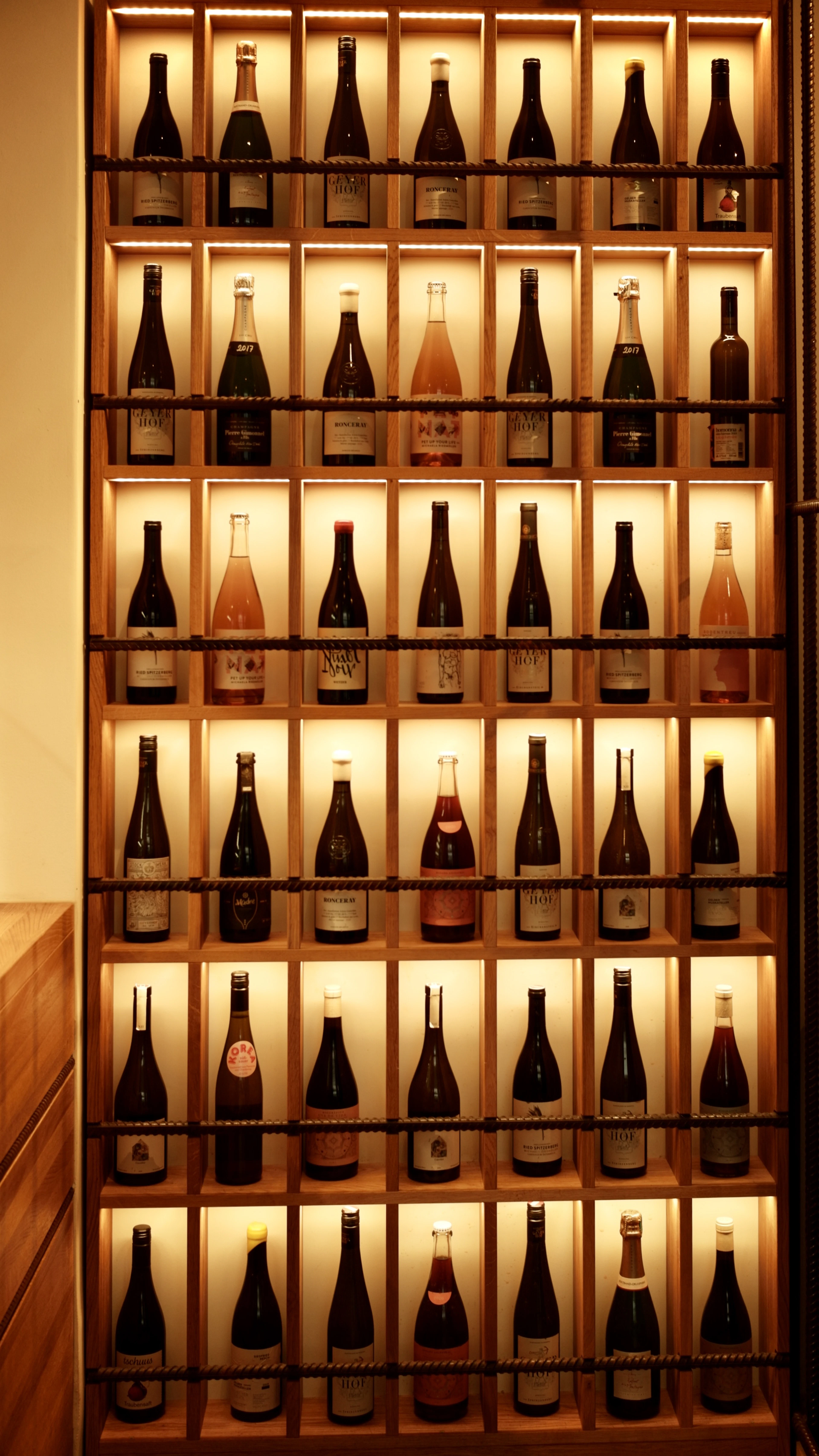 Illuminated wine cubbies in warm wood