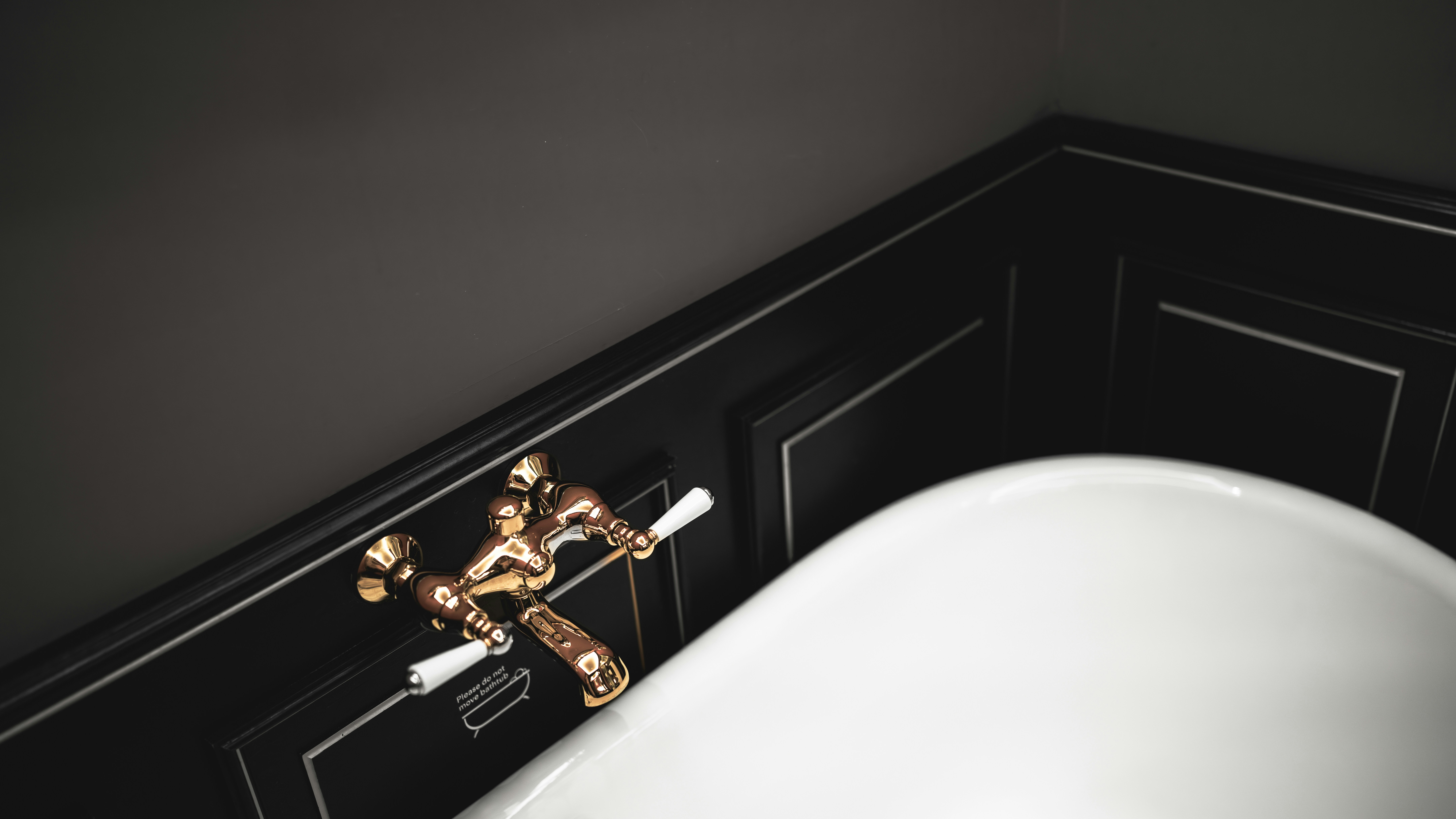 Kamar mandi dengan wastafel putih dan dinding hitam