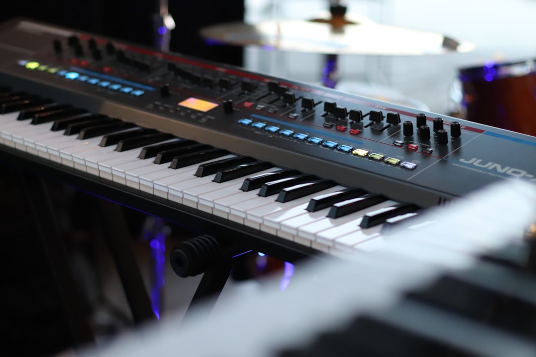 A close up of a keyboard with a drum in the background, A close-up shot of a Roland Juno synthesizer keyboard in a music studio, showcasing its detailed control panel and keys