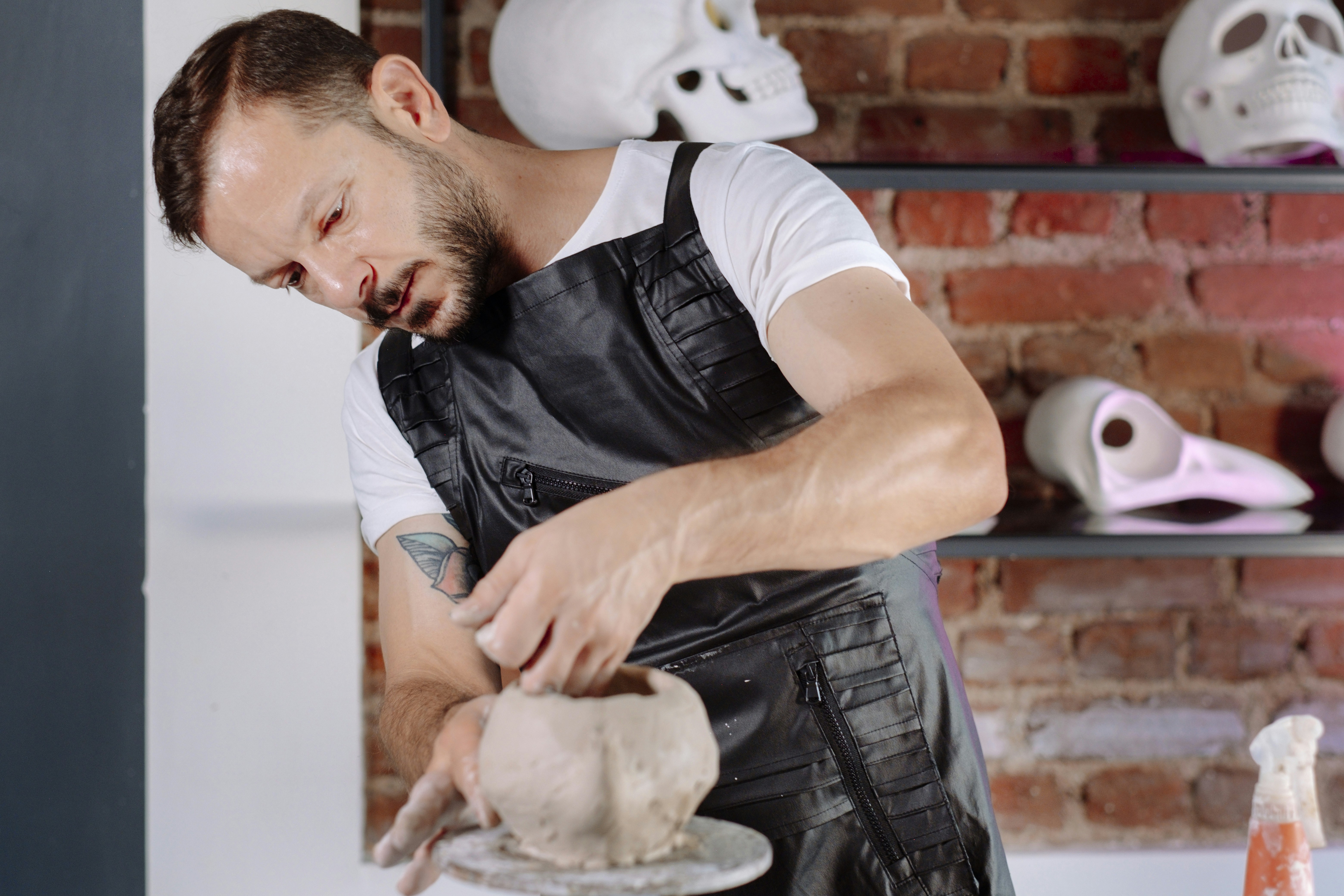A man in an apron is making a doughnut