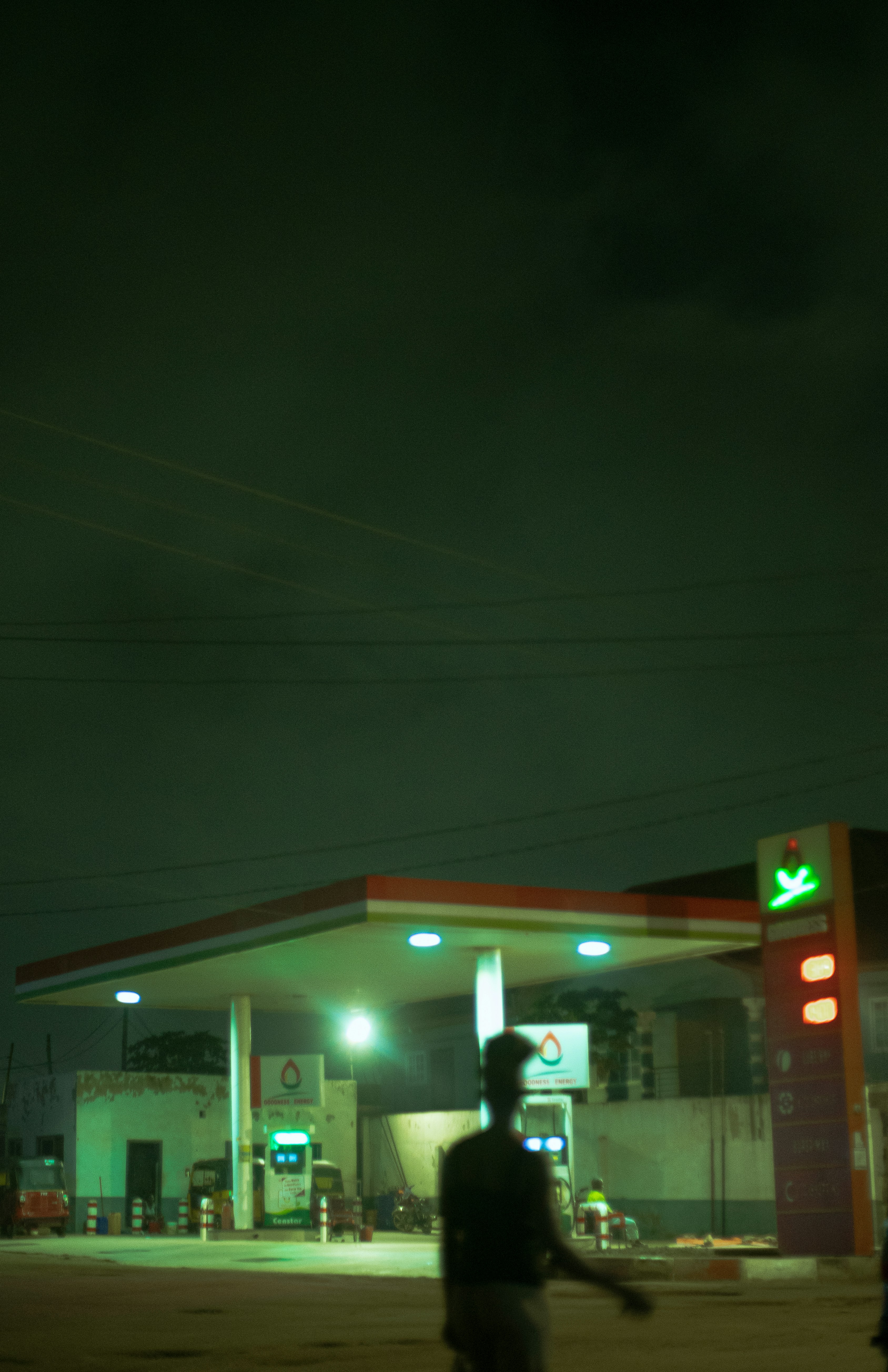 A gas station at night with people walking by