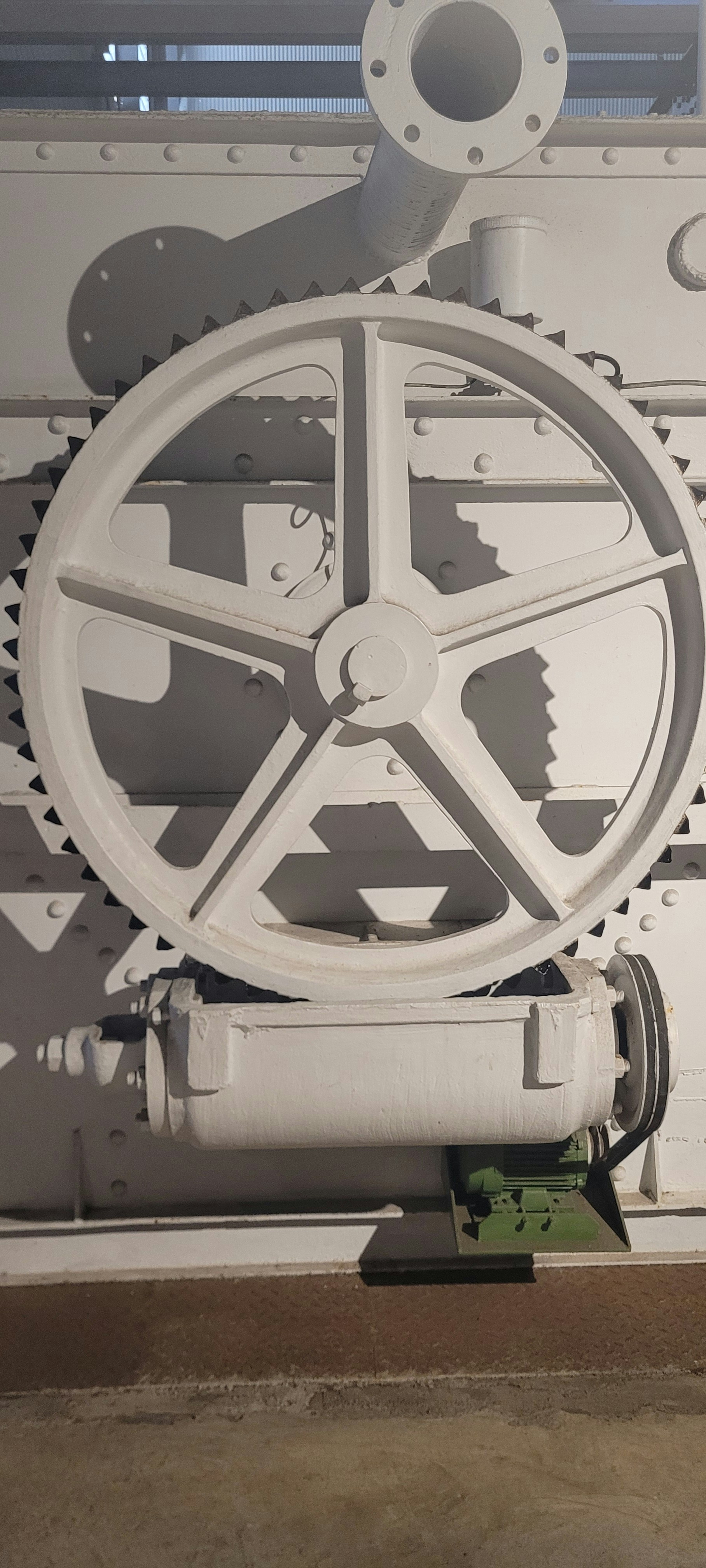 Eine große weiße Maschine mit Zahnrädern an der Seite
