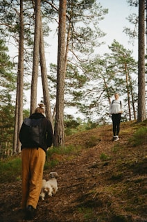 A couple of people walking down a dirt road