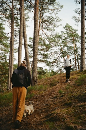A couple of people walking down a dirt road
