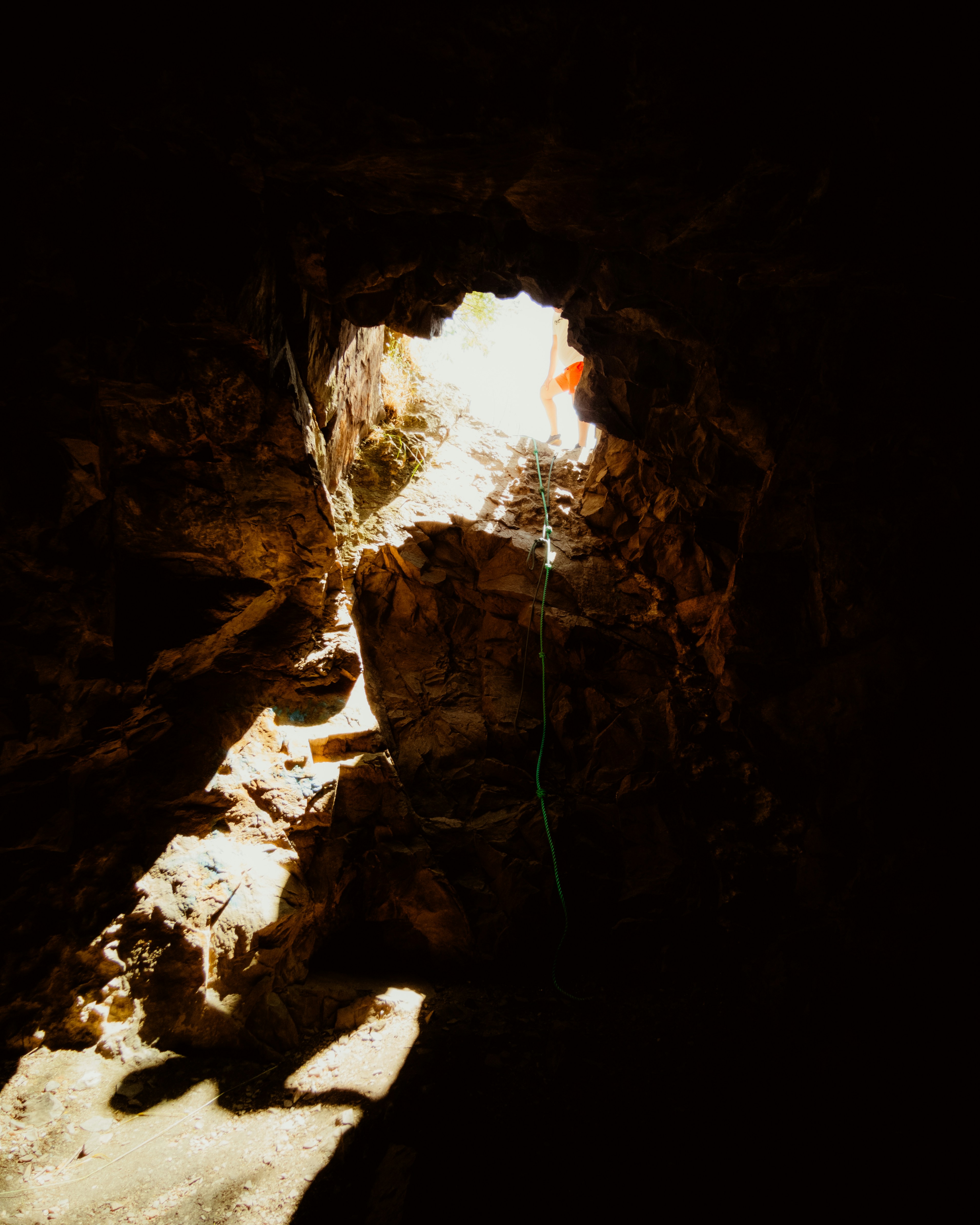 A light shines through a hole in a cave